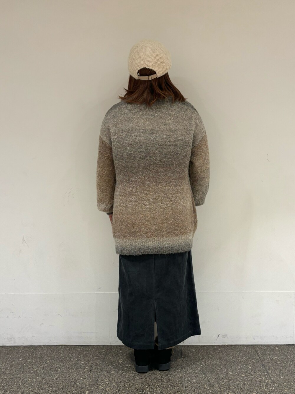 ベージュ系のニット/セーター、ブルー系のスカートを着用したレディースの冬コーディネートの3枚目の写真