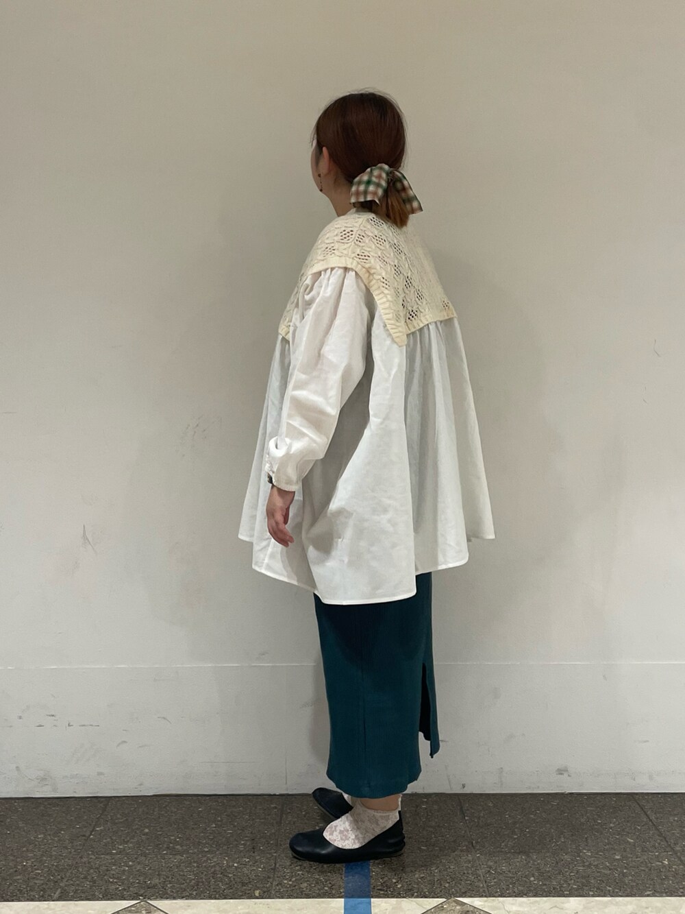 ホワイト系のチュニック、グリーン系のスカートを着用したレディースの秋コーディネートの2枚目の写真