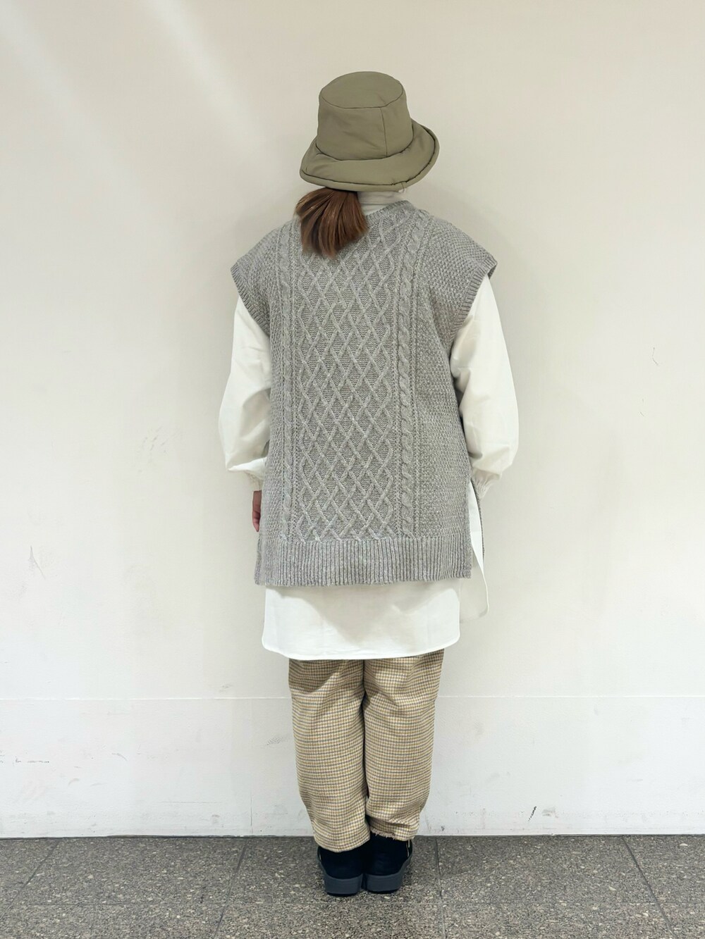 ベージュ系のベストを着用したレディースの冬コーディネートの3枚目の写真