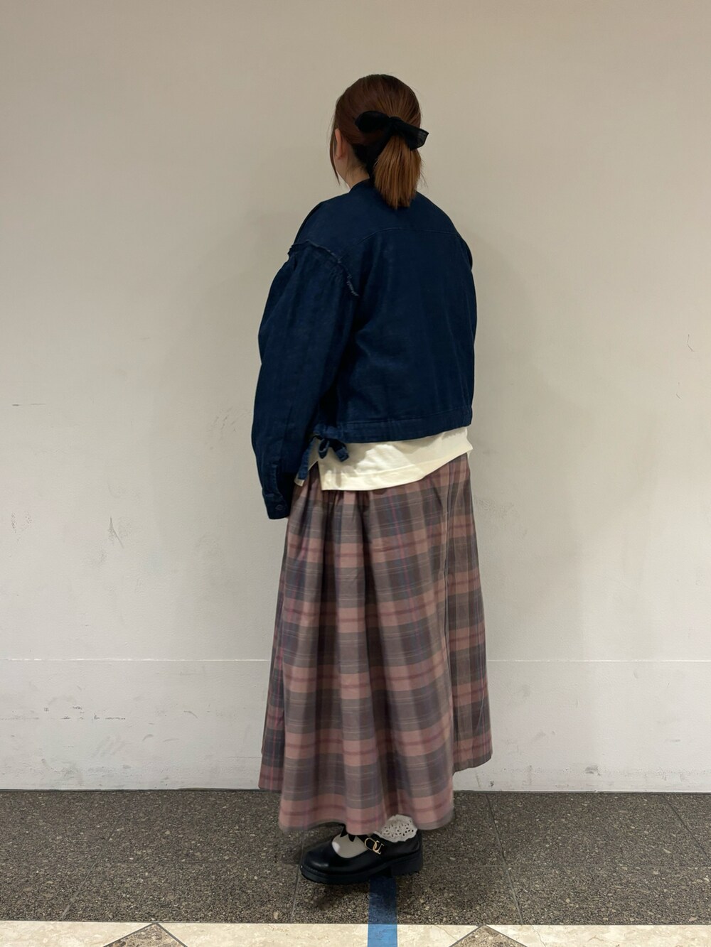 ブルー系のノーカラージャケット、ホワイト系のTシャツ/カットソー、ピンク系のスカートを着用したレディースの秋コーディネートの2枚目の写真