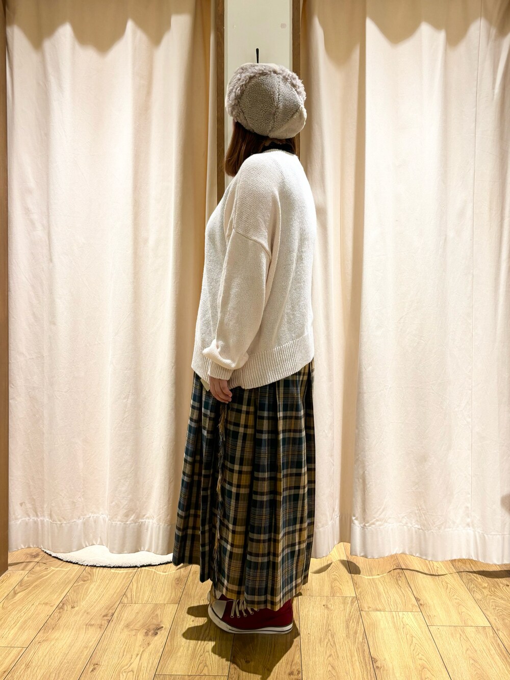 ホワイト系のカーディガン/ボレロ、グリーン系のスカート、ベージュ系のハットを着用したレディースの冬コーディネートの2枚目の写真