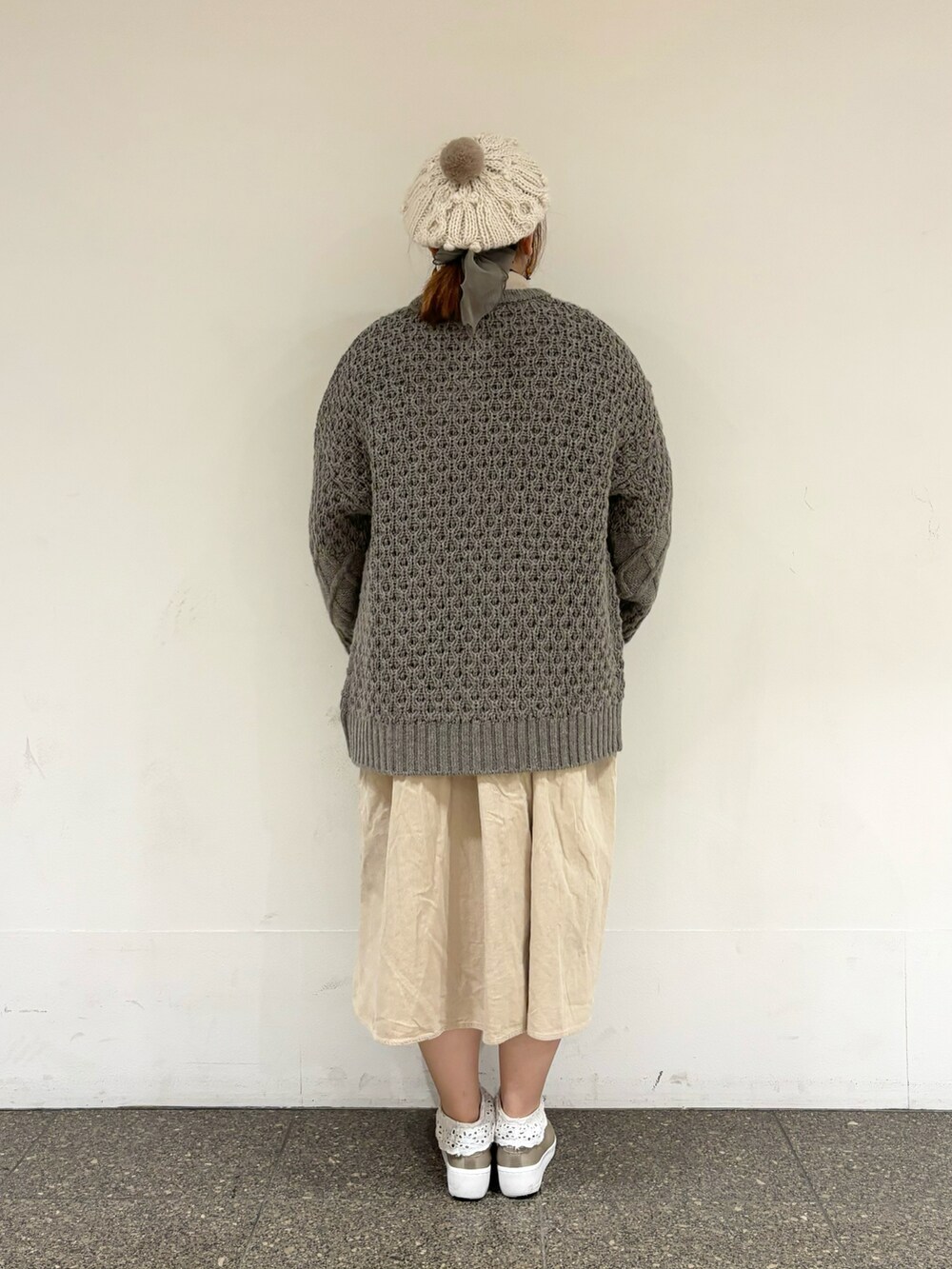 ブラウン系のカーディガン/ボレロ、ベージュ系のワンピース、ホワイト系のハットを着用したレディースの冬コーディネートの3枚目の写真