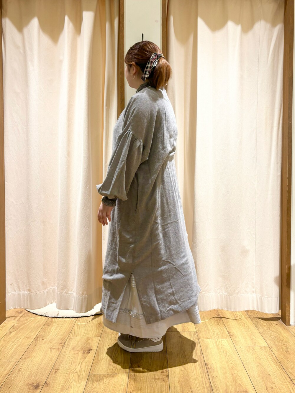 グレー系のワンピース、ブルー系のスカートを着用したレディースの冬コーディネートの2枚目の写真