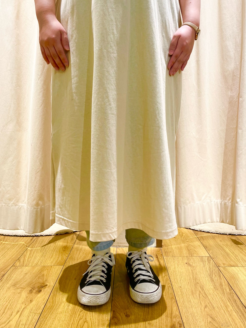 ベージュ系のワンピース、ブルー系のデニムパンツを着用したレディースの春コーディネートの5枚目の写真