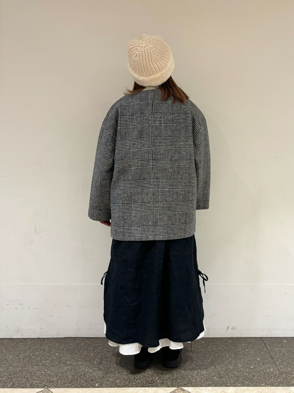 グレー系のその他アウター、ブラック系のワンピース、ホワイト系のスカートを着用したレディースの冬コーディネートの3枚目の写真