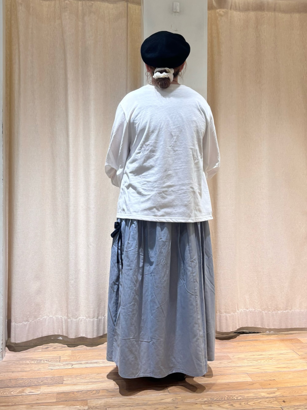 ホワイト系のTシャツ/カットソー、ブルー系のスカート、ブラック系のハットを着用したレディースの春コーディネートの3枚目の写真