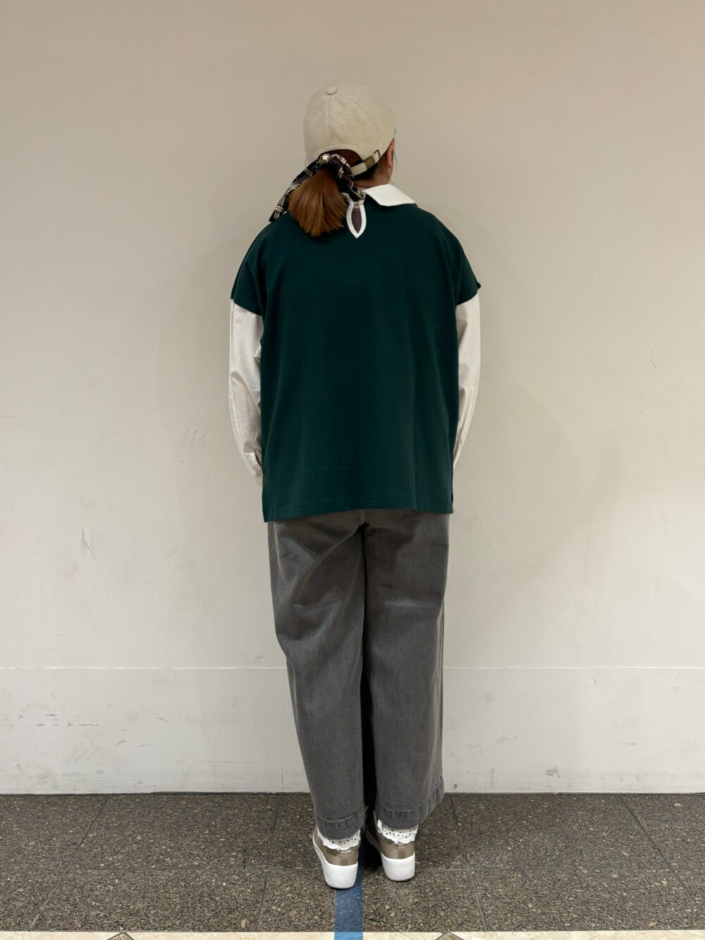 グリーン系のTシャツ/カットソー、グレー系のデニムパンツ、ホワイト系のハットを着用したレディースの秋コーディネートの3枚目の写真