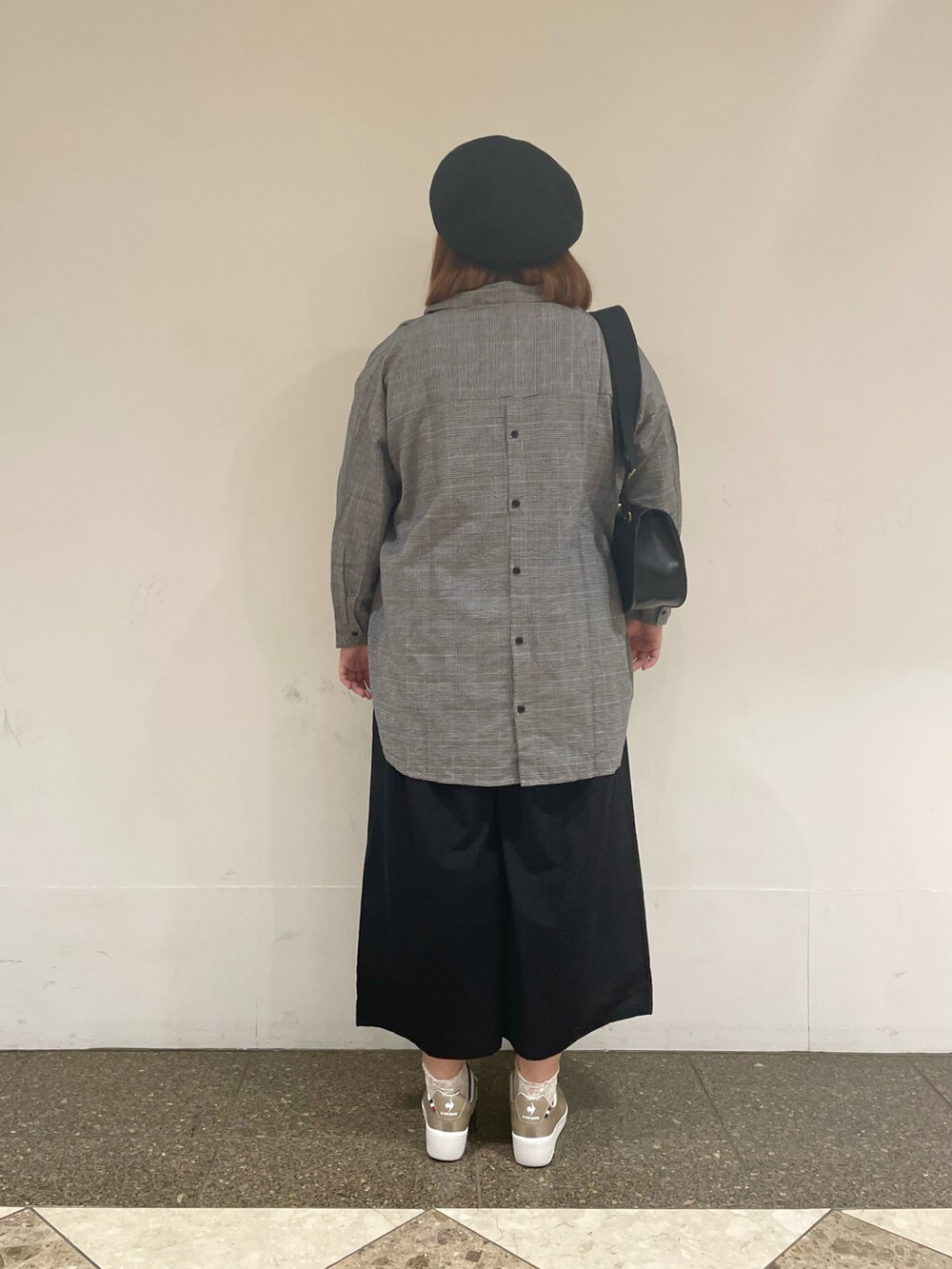 ブラック系のチュニック、ブラック系のその他パンツ、ブラック系のハンドバッグを着用したレディースの秋コーディネートの3枚目の写真