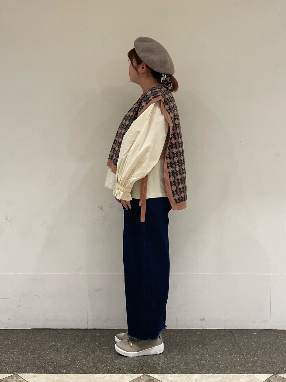 ピンク系のベスト、ホワイト系のTシャツ/カットソー、ブルー系のデニムパンツを着用したレディースの秋コーディネートの2枚目の写真