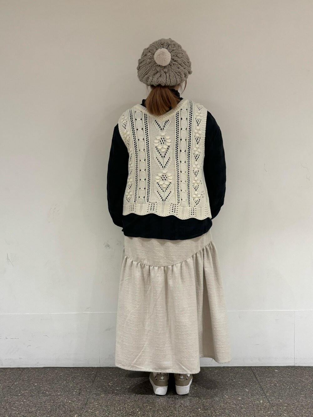 ホワイト系のベスト、ホワイト系のスカート、ブラウン系のハットを着用したレディースの冬コーディネートの3枚目の写真