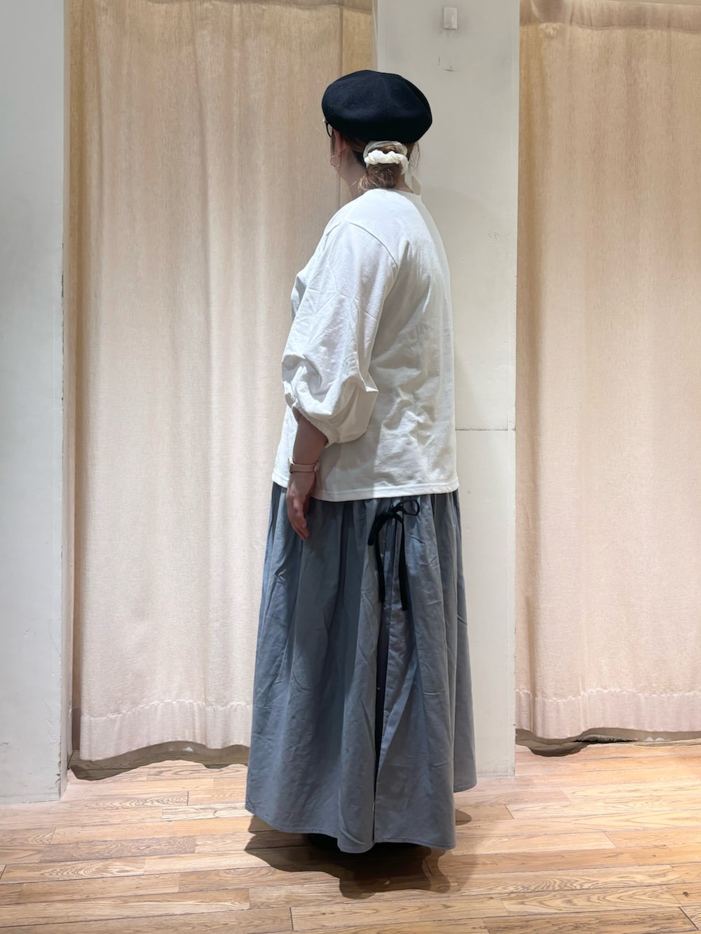 ホワイト系のTシャツ/カットソー、ブルー系のスカート、ブラック系のハットを着用したレディースの春コーディネートの2枚目の写真