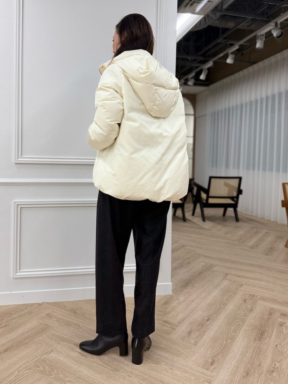 ホワイト系のダウンジャケット/コート、ブルー系のニット/セーター、グレー系のパンツを着用したレディースの秋コーディネートの2枚目の写真