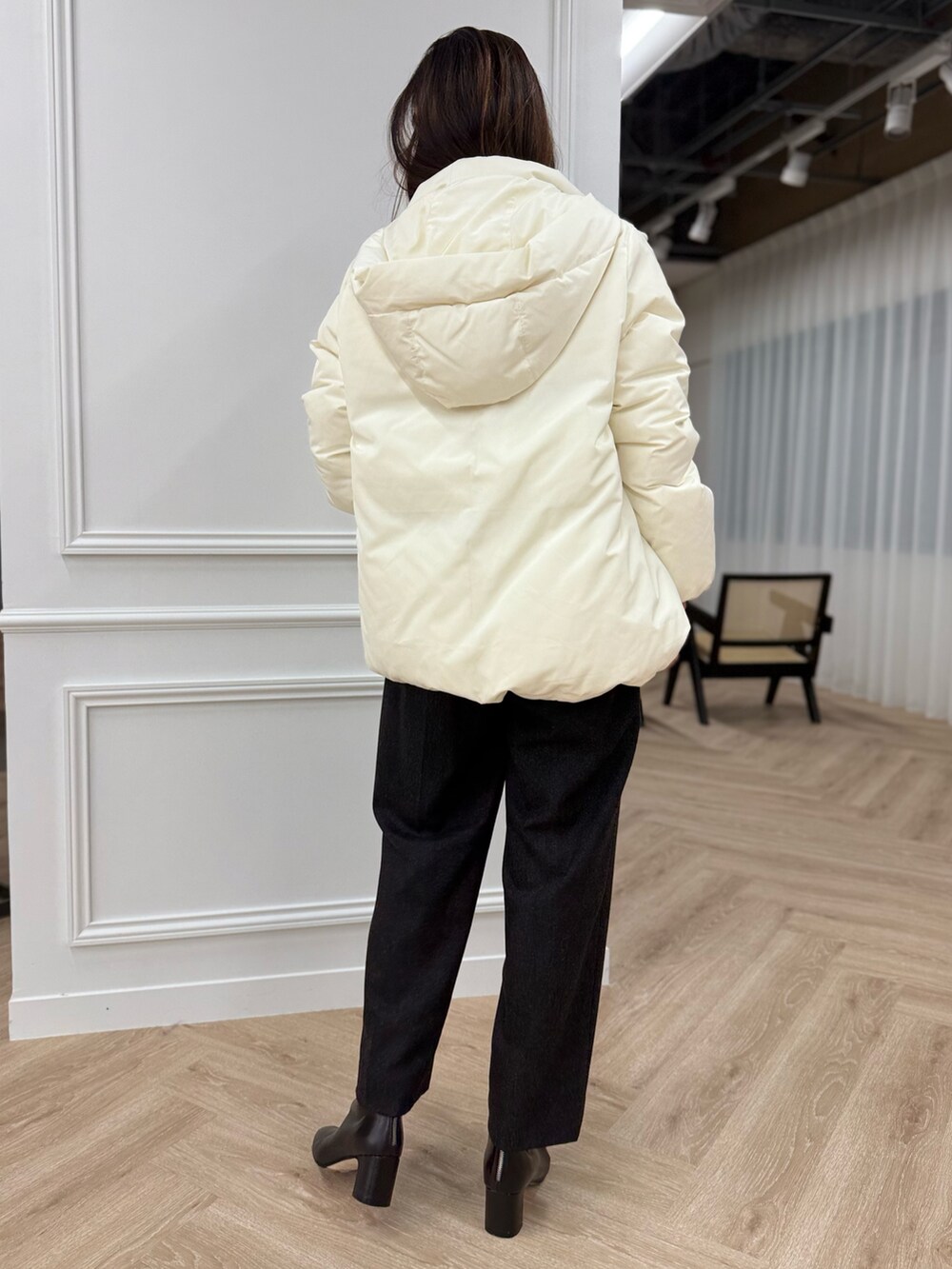 ホワイト系のダウンジャケット/コート、ブルー系のニット/セーター、グレー系のパンツを着用したレディースの秋コーディネートの3枚目の写真