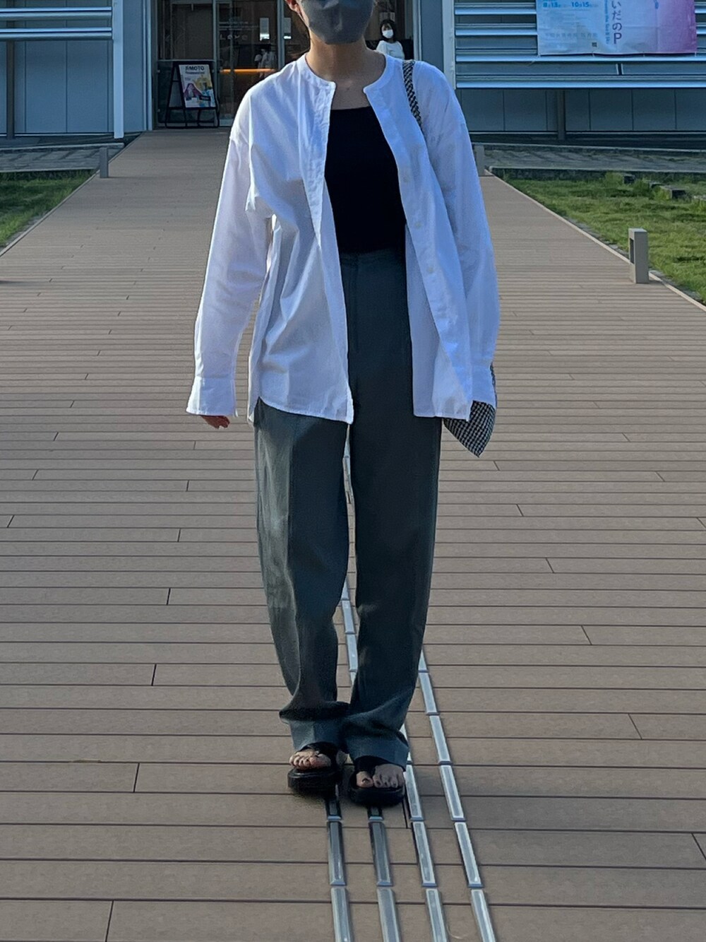 グレー系のパンツ、ホワイト系のシャツ/ブラウスを着用したレディースの秋コーディネートの2枚目の写真