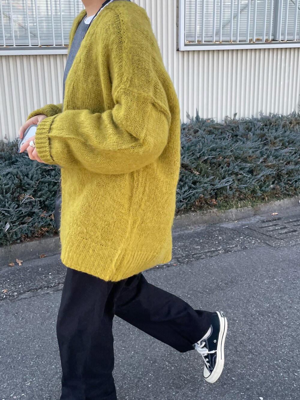 ブラック系のスニーカー、イエロー系のカーディガン/ボレロ、グレー系のトップスを着用したレディースの秋コーディネートの2枚目の写真