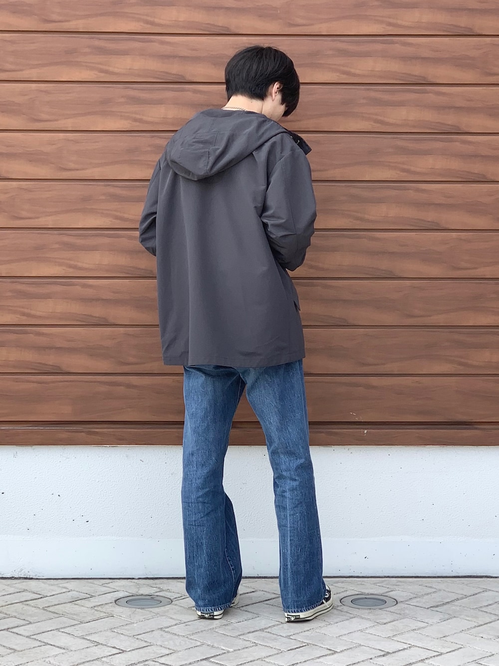 ブラック系のマウンテンパーカー、ブルー系のTシャツ/カットソー、ブルー系のデニムパンツを着用したメンズの春コーディネートの3枚目の写真