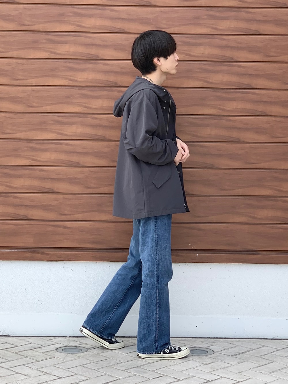 ブラック系のマウンテンパーカー、ブルー系のTシャツ/カットソー、ブルー系のデニムパンツを着用したメンズの春コーディネートの4枚目の写真