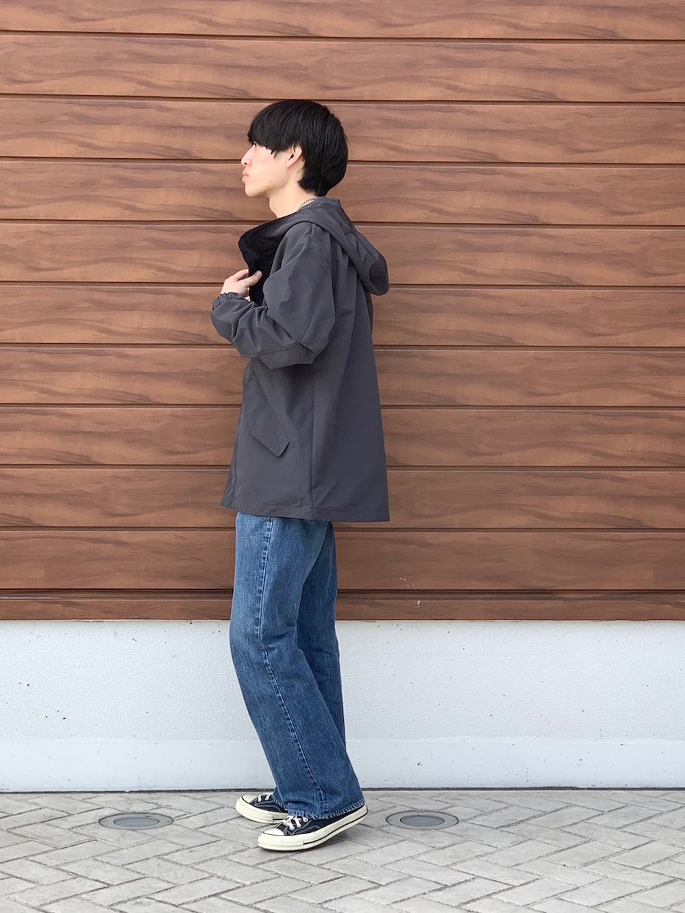 ブラック系のマウンテンパーカー、ブルー系のTシャツ/カットソー、ブルー系のデニムパンツを着用したメンズの春コーディネートの2枚目の写真