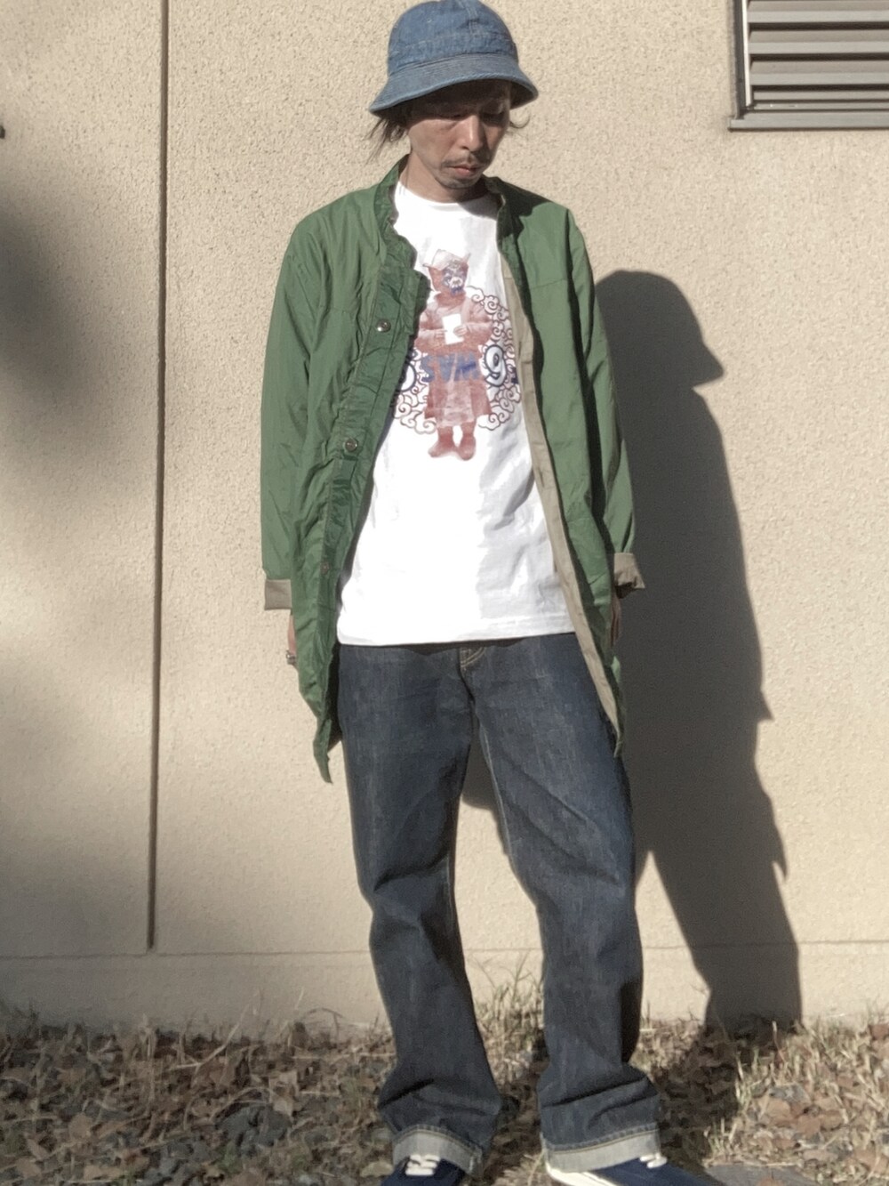 グリーン系のジャケット/アウター、ホワイト系のトップス、ブルー系のパンツを着用したメンズの春コーディネートの2枚目の写真