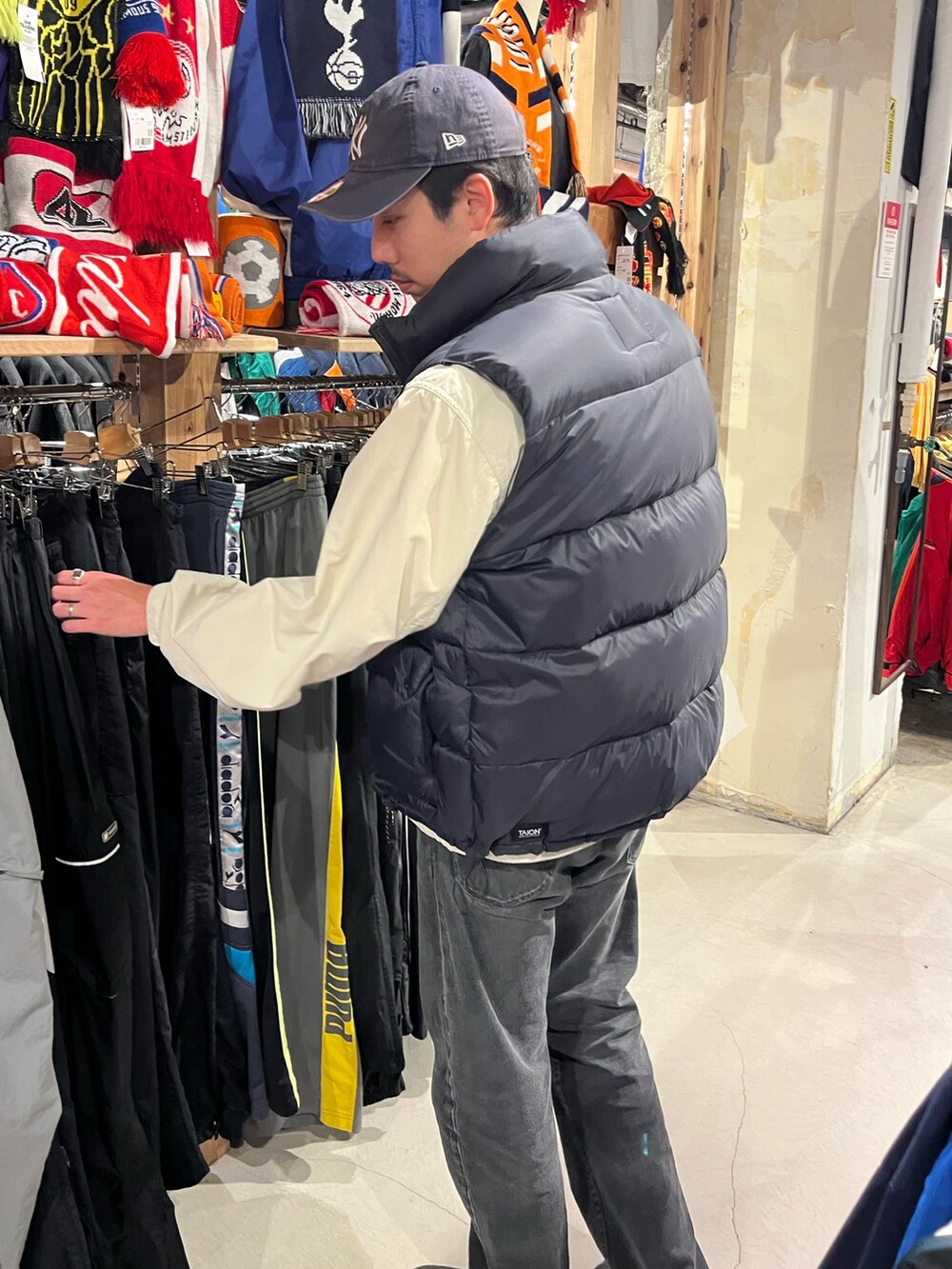 「春色、ダウンベスト、レイヤードスタイル、大人カジュアル、大人コーデ、古着MIX、ナイロンジャケット、バンドT、プリントT、デニム、春コーデ、春、春アウター、春服、お洒落さんとつながりたい」｜「SUBUの【SUBU/スブ】F-line ウインターサンダル UNISEX/ユニセックス（サンダル、ブラック系）」を使った、ハヤシさん（骨格ストレート・メンズ・183cm）の春コーディネートの2枚目の写真