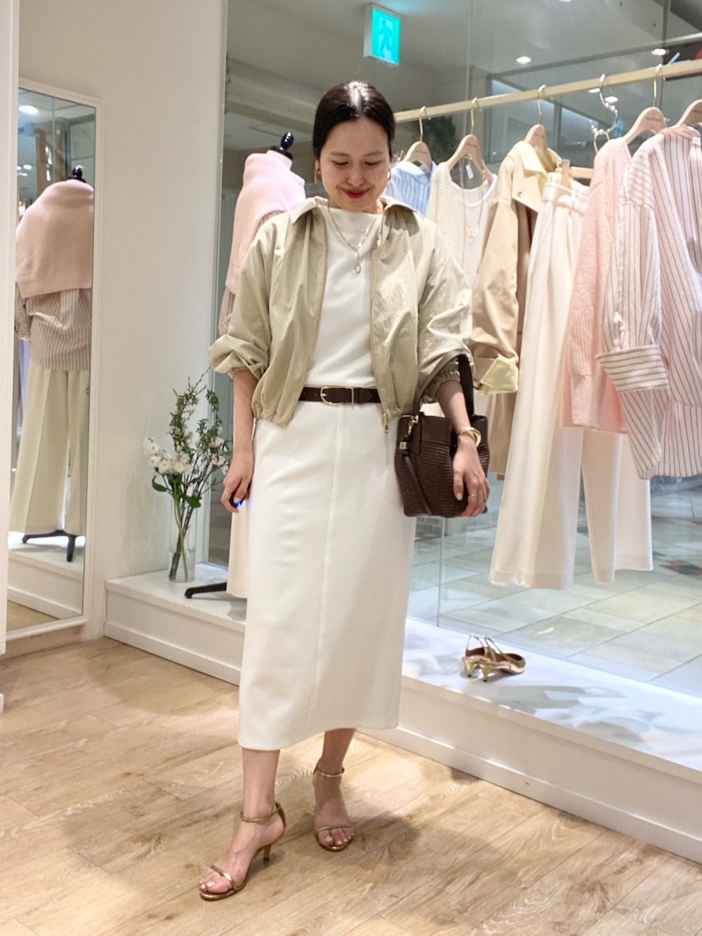 ホワイト系のTシャツ/カットソー、ホワイト系のスカート、ベージュ系のブルゾンを着用したレディースの冬コーディネートの4枚目の写真