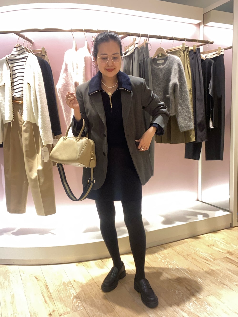 ブルー系のニット/セーター、グレー系のテーラードジャケット、ベージュ系のショルダーバッグを着用したレディースの秋コーディネートの2枚目の写真