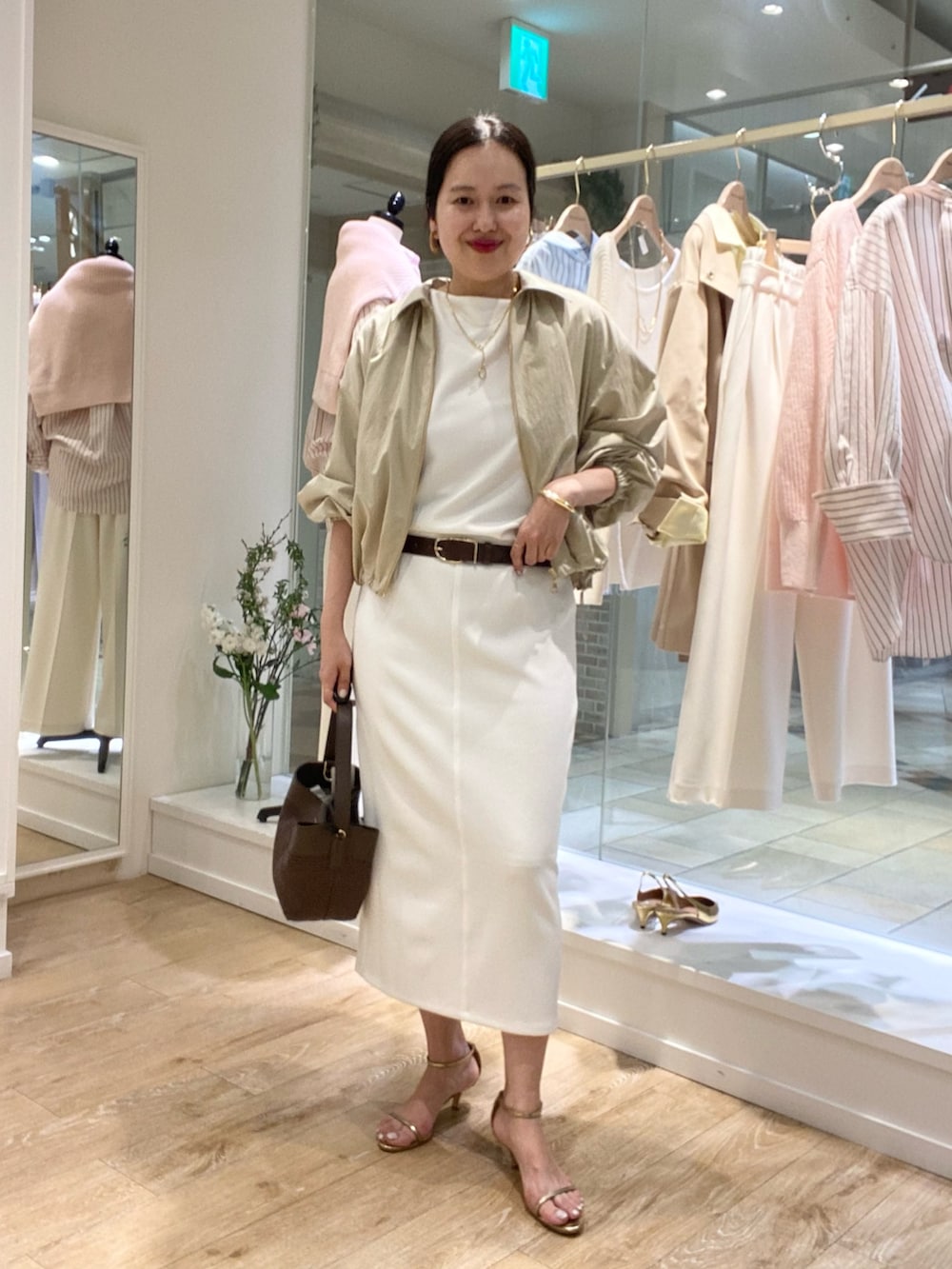 ホワイト系のTシャツ/カットソー、ホワイト系のスカート、ベージュ系のブルゾンを着用したレディースの冬コーディネートの3枚目の写真