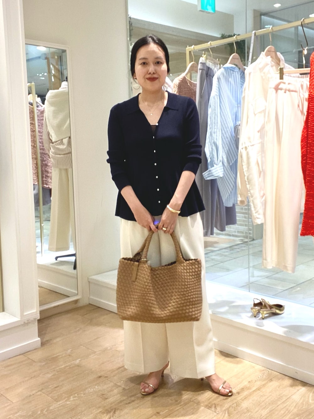 ブルー系のカーディガン/ボレロ、ホワイト系のその他パンツ、ブラウン系のトートバッグを着用したレディースの春コーディネートの5枚目の写真