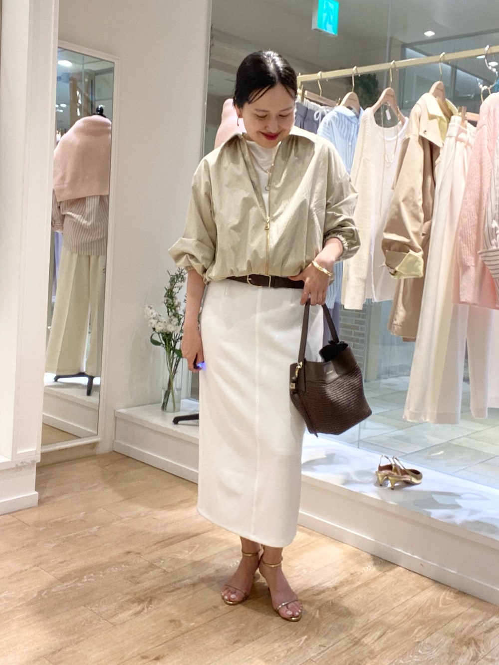 ホワイト系のTシャツ/カットソー、ホワイト系のスカート、ベージュ系のブルゾンを着用したレディースの冬コーディネートの2枚目の写真