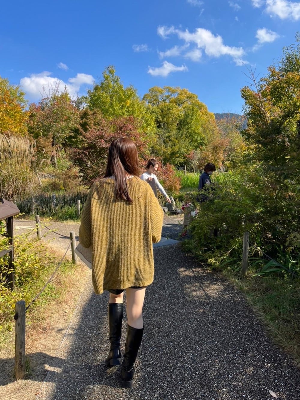 グリーン系のカーディガン/ボレロ、ブラック系のブーツ、ブラック系のその他パンツを着用したレディースの秋コーディネートの2枚目の写真