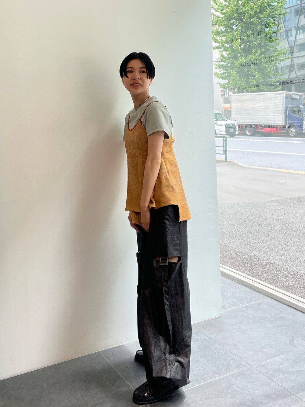 オレンジ系のキャミソール、ブラック系のカーゴパンツ、グリーン系のTシャツ/カットソーを着用したレディースの春コーディネートの2枚目の写真