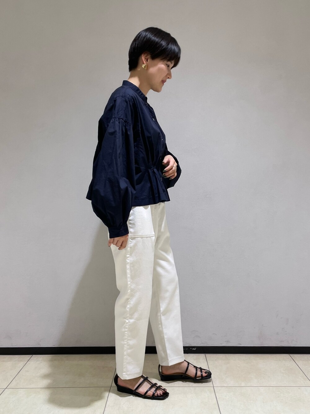 ブルー系のシャツ/ブラウス、ホワイト系のスラックス、ブラック系のサンダルを着用したレディースの春コーディネートの2枚目の写真