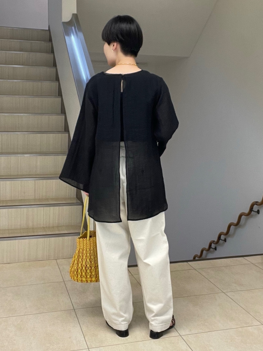 ブラック系のシャツ/ブラウス、ホワイト系のデニムパンツ、イエロー系のショルダーバッグを着用したレディースの春コーディネートの3枚目の写真