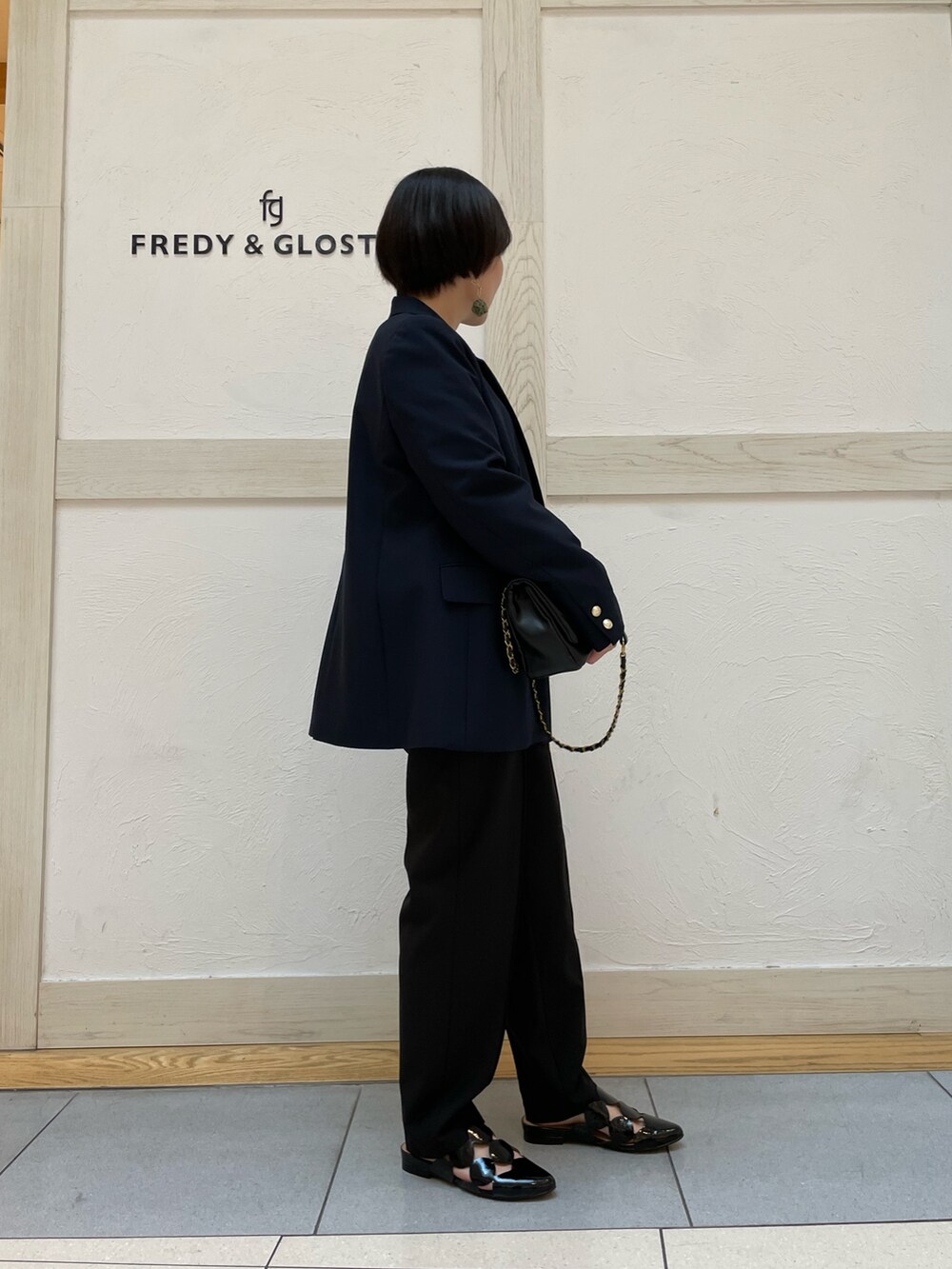 グリーン系のTシャツ/カットソー、ブルー系のテーラードジャケット、ブラック系のスラックスを着用したレディースの春コーディネートの2枚目の写真