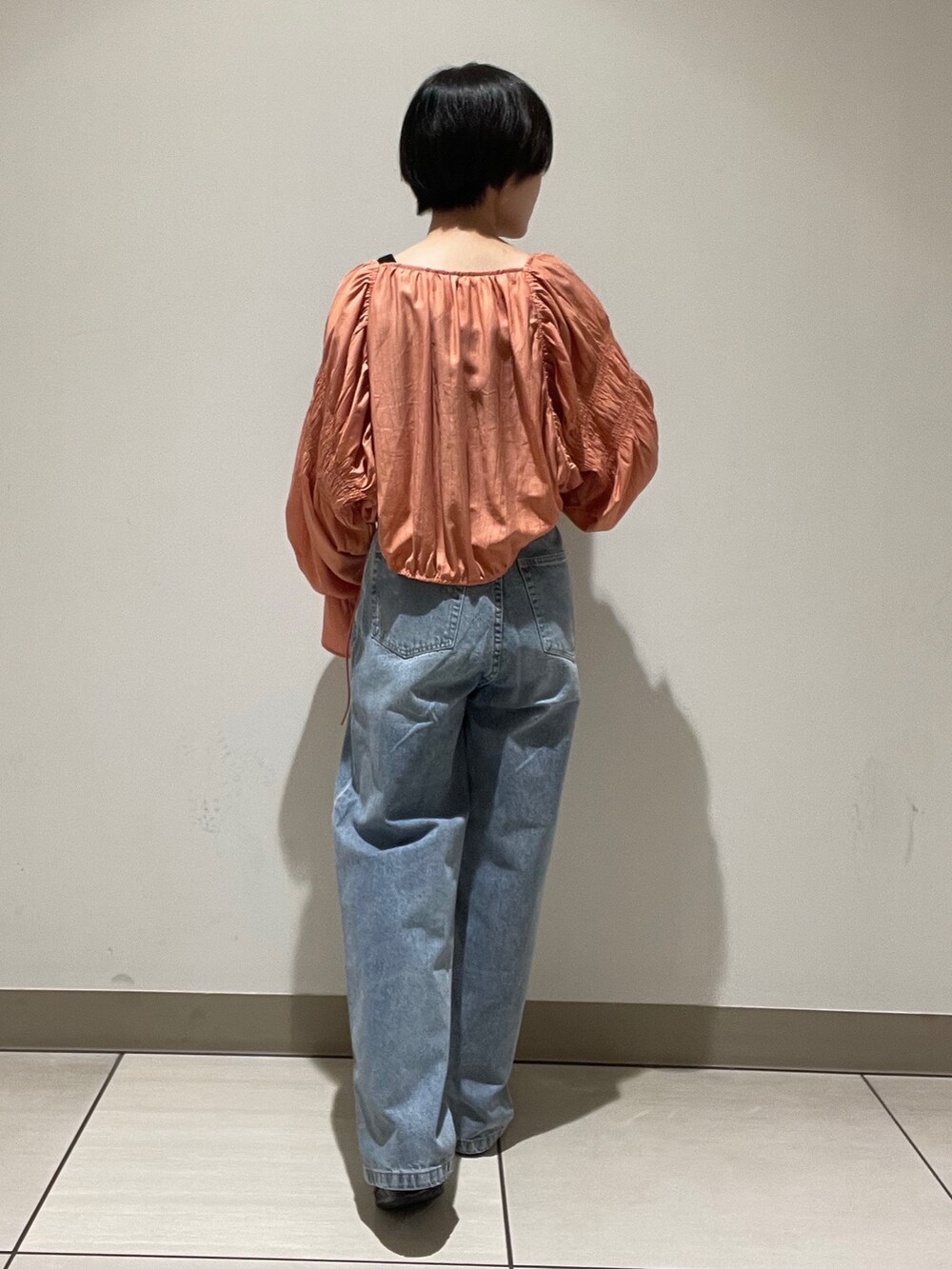 オレンジ系のシャツ/ブラウス、ブルー系のデニムパンツを着用したレディースの夏コーディネートの3枚目の写真