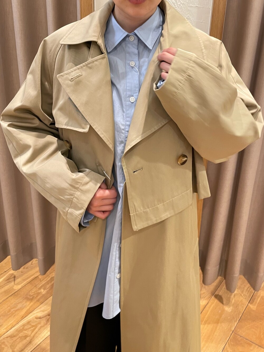 ベージュ系のトレンチコート、ブルー系のシャツ/ブラウス、ブラック系のスラックスを着用したレディースの春コーディネートの4枚目の写真