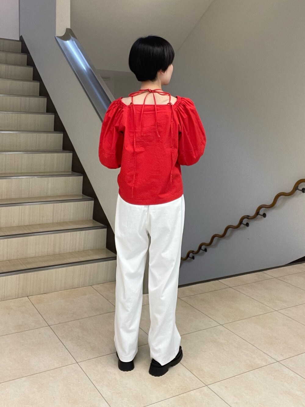 レッド系のシャツ/ブラウス、ホワイト系のスラックス、ブラック系のサンダルを着用したレディースの春コーディネートの3枚目の写真