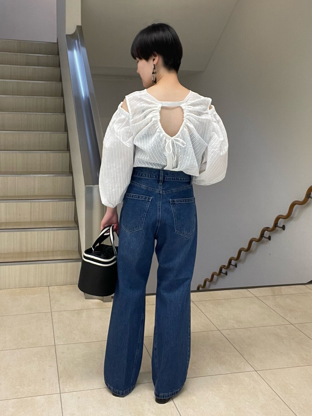 ホワイト系のシャツ/ブラウス、ブルー系のデニムパンツ、ブラック系のトートバッグを着用したレディースの春コーディネートの3枚目の写真