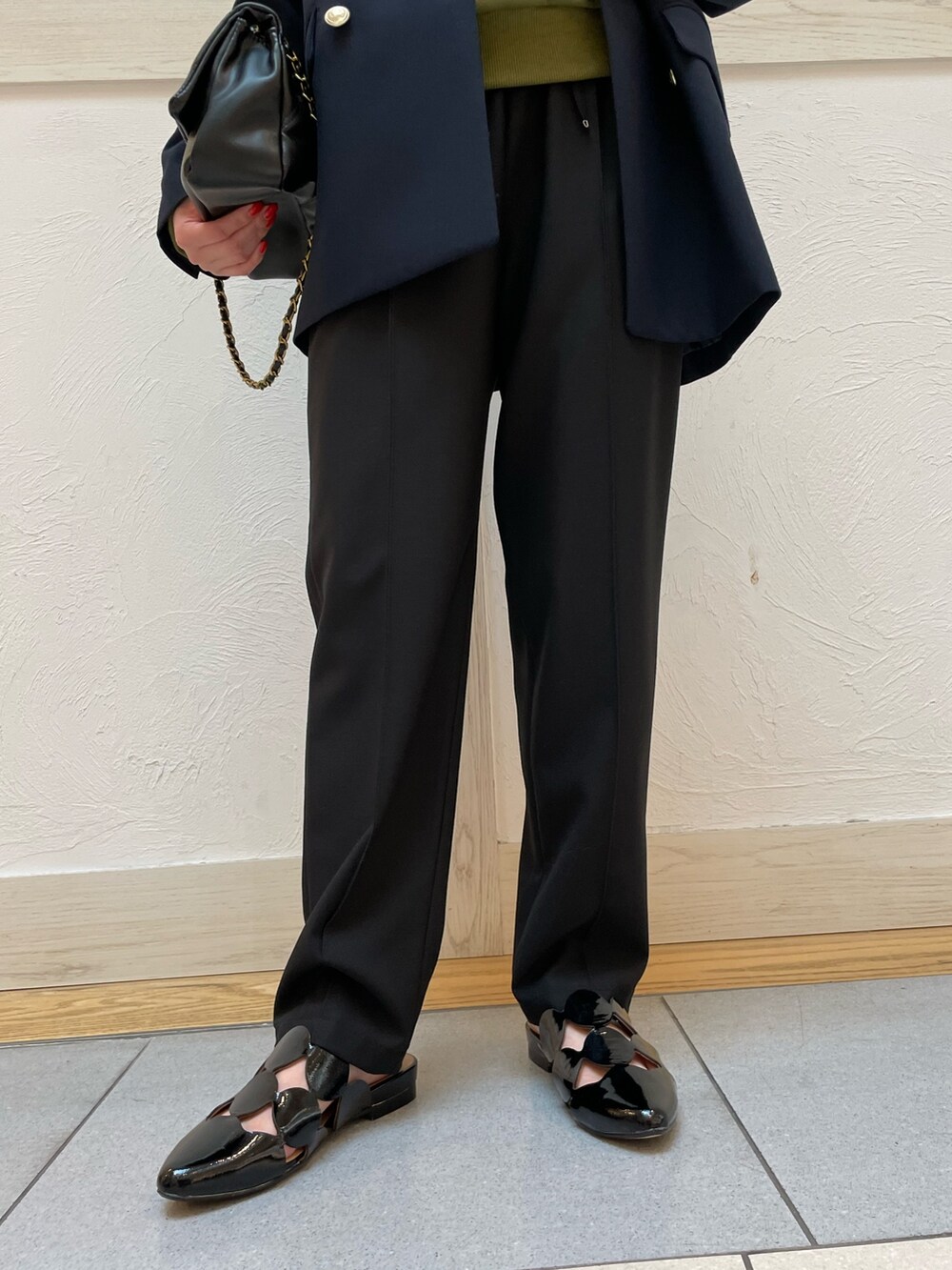 グリーン系のTシャツ/カットソー、ブルー系のテーラードジャケット、ブラック系のスラックスを着用したレディースの春コーディネートの6枚目の写真