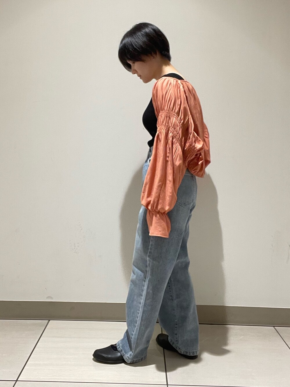 オレンジ系のシャツ/ブラウス、ブルー系のデニムパンツを着用したレディースの夏コーディネートの2枚目の写真