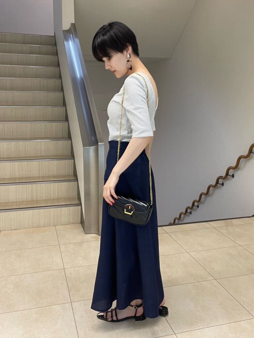 ホワイト系のTシャツ/カットソー、ブルー系のスカート、ブラック系のショルダーバッグを着用したレディースの春コーディネートの2枚目の写真