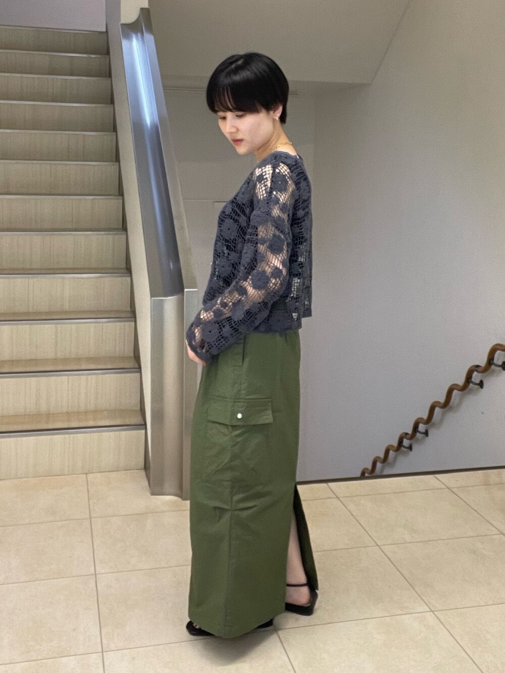 グレー系のカーディガン/ボレロ、グリーン系のスカート、ブラック系のサンダルを着用したレディースの夏コーディネートの2枚目の写真