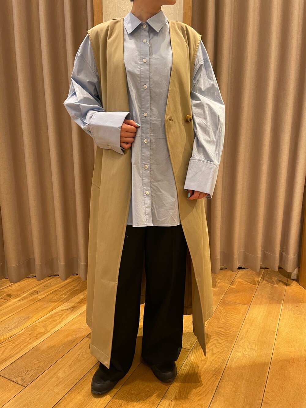 ベージュ系のトレンチコート、ブルー系のシャツ/ブラウスを着用したレディースの春コーディネートの4枚目の写真