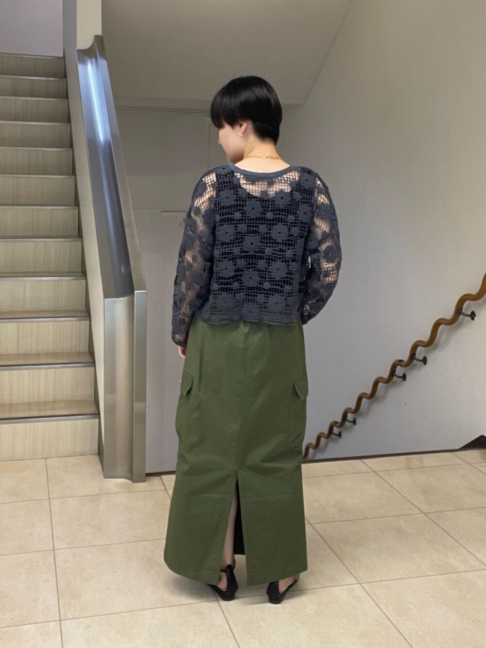 グレー系のカーディガン/ボレロ、グリーン系のスカート、ブラック系のサンダルを着用したレディースの夏コーディネートの3枚目の写真