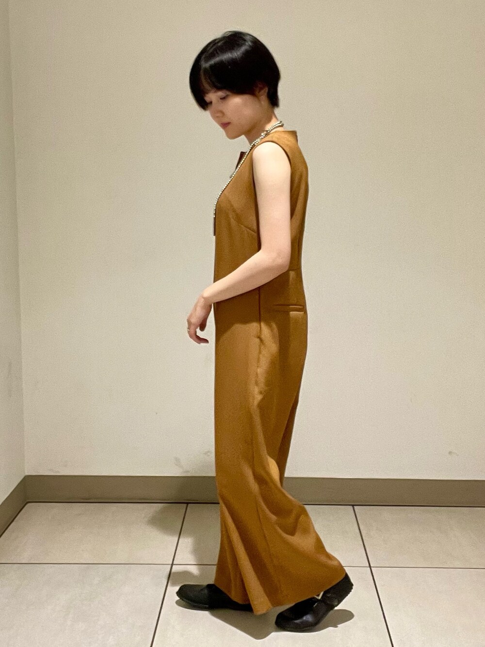 イエロー系のつなぎ/オールインワンを着用したレディースの夏コーディネートの2枚目の写真