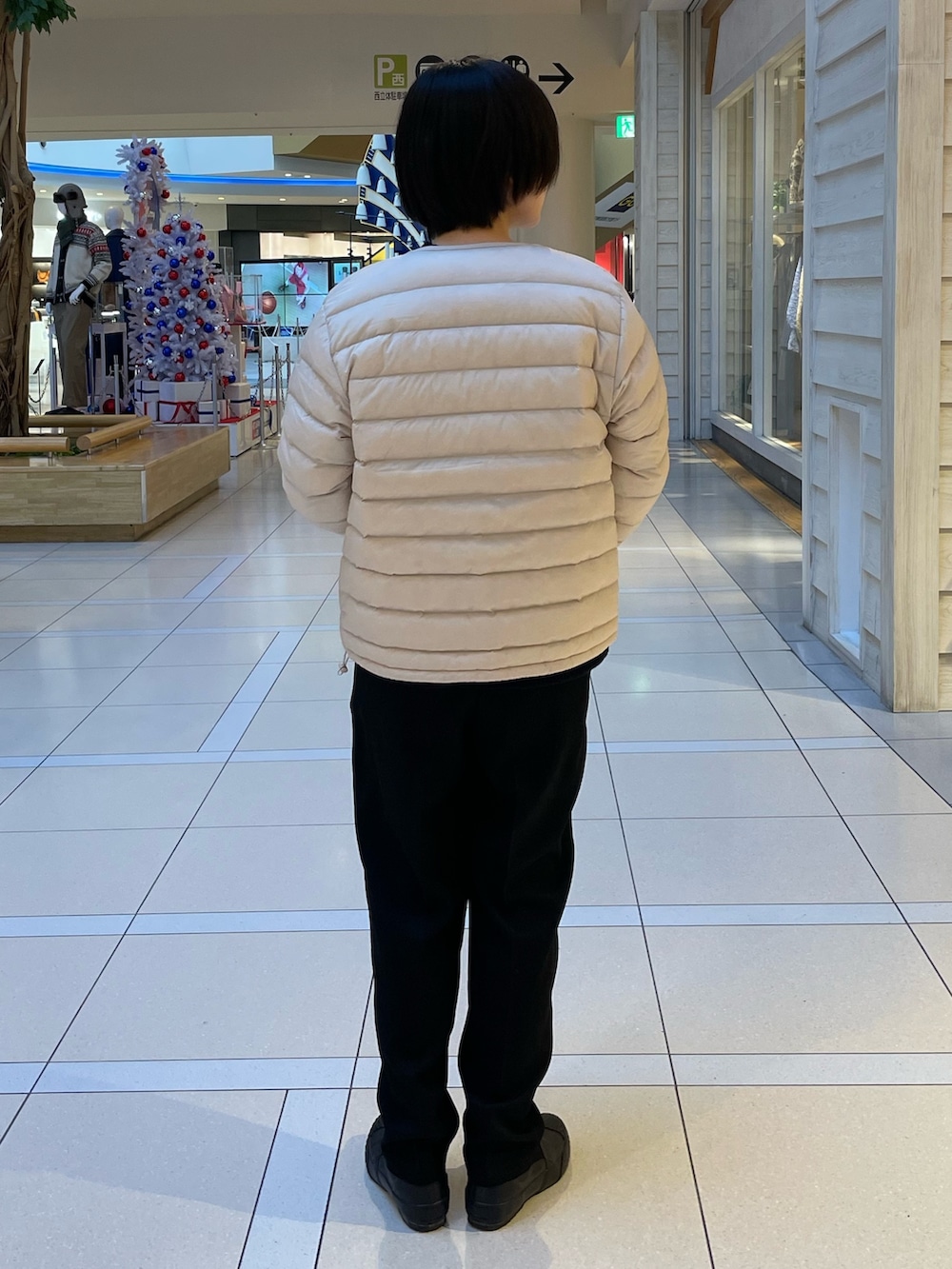 ブルー系のニット/セーター、ホワイト系のダウンジャケット/コート、ブラック系のスラックスを着用したレディースの冬コーディネートの3枚目の写真