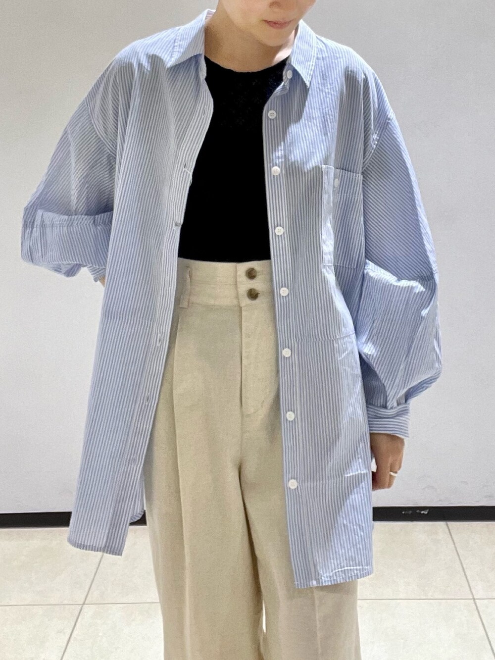 ブルー系のシャツ/ブラウス、ブラック系のTシャツ/カットソー、ベージュ系のスラックスを着用したレディースの夏コーディネートの4枚目の写真