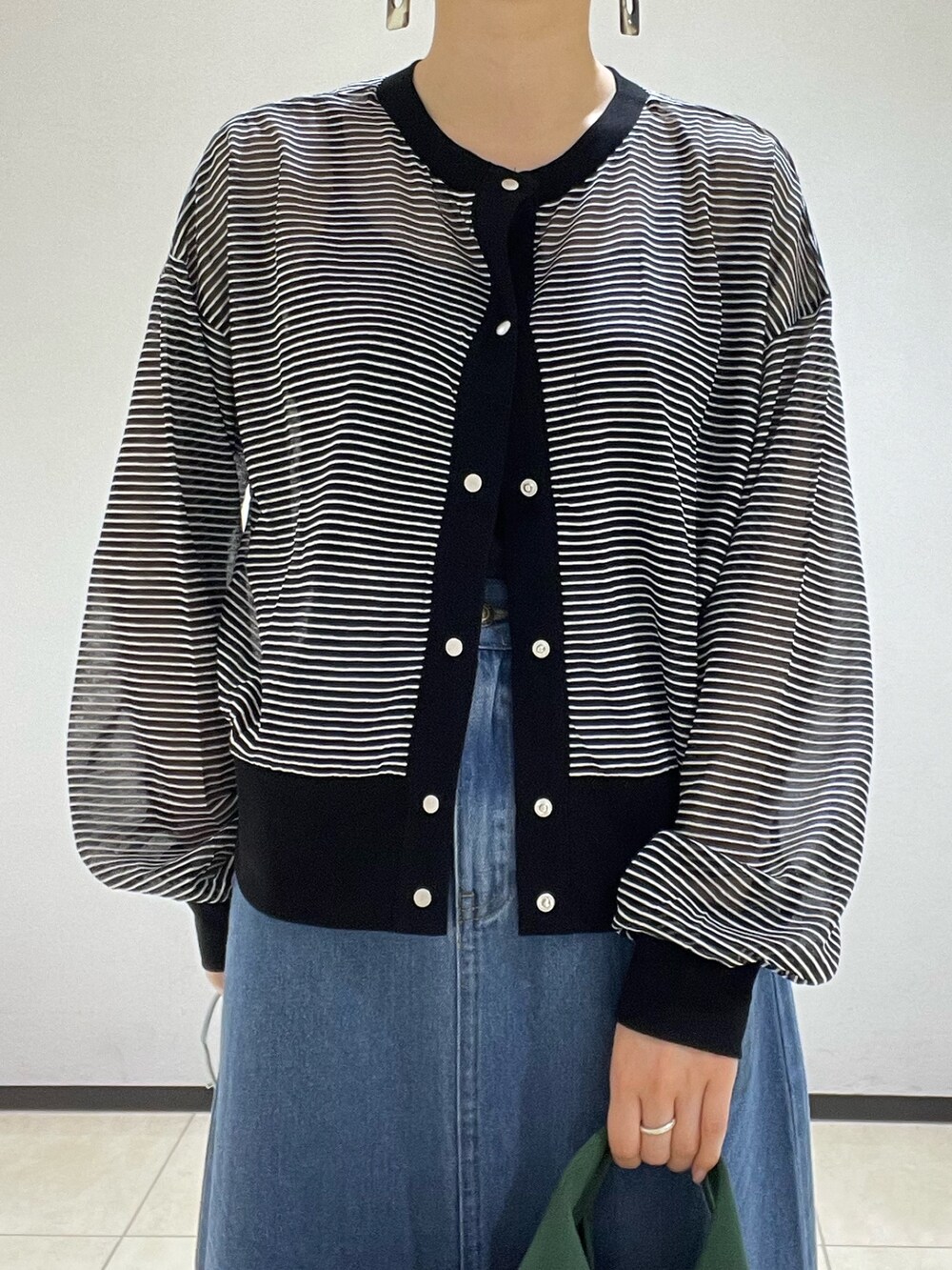 ブラック系のカーディガン/ボレロ、グリーン系のかごバッグ、ブルー系のデニムスカートを着用したレディースの夏コーディネートの4枚目の写真