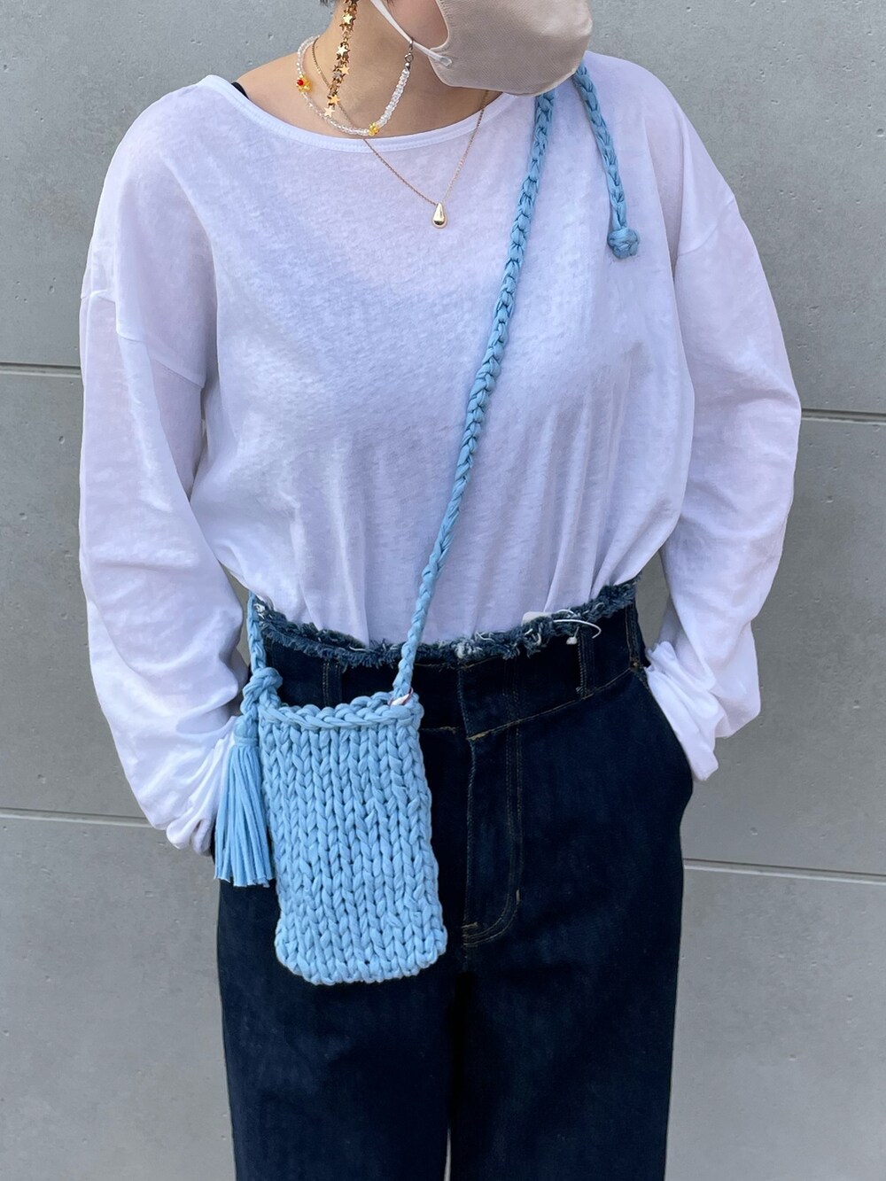 ホワイト系のTシャツ/カットソー、ブルー系のデニムパンツ、ブラック系のサンダルを着用したレディースの春コーディネートの4枚目の写真