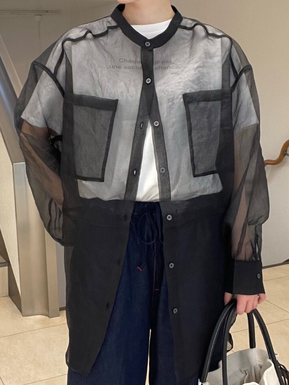 ブラック系のシャツ/ブラウス、パープル系のTシャツ/カットソー、ブルー系のデニムパンツを着用したレディースの春コーディネートの5枚目の写真